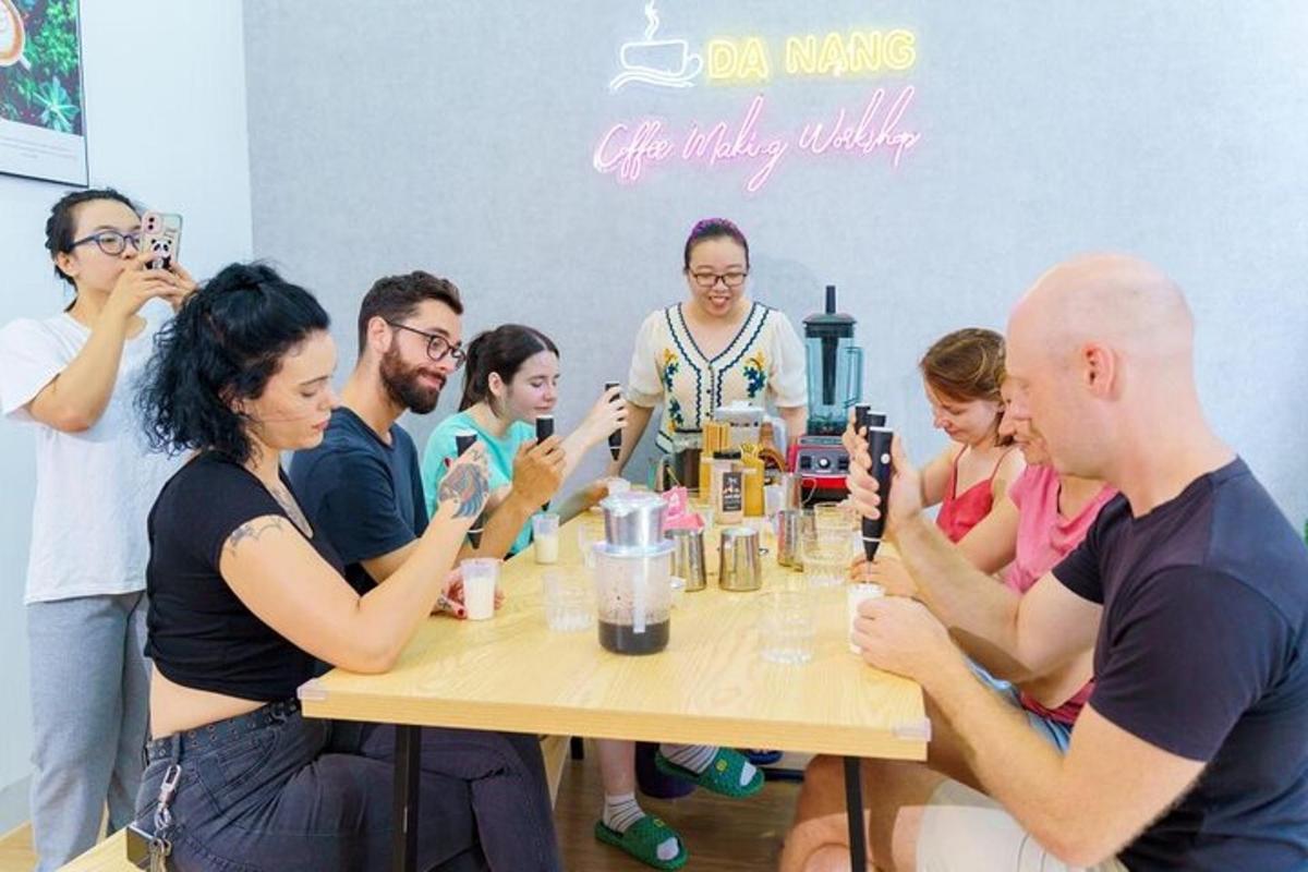 un gruppo di persone sedute attorno a un tavolo con in mano un cellulare