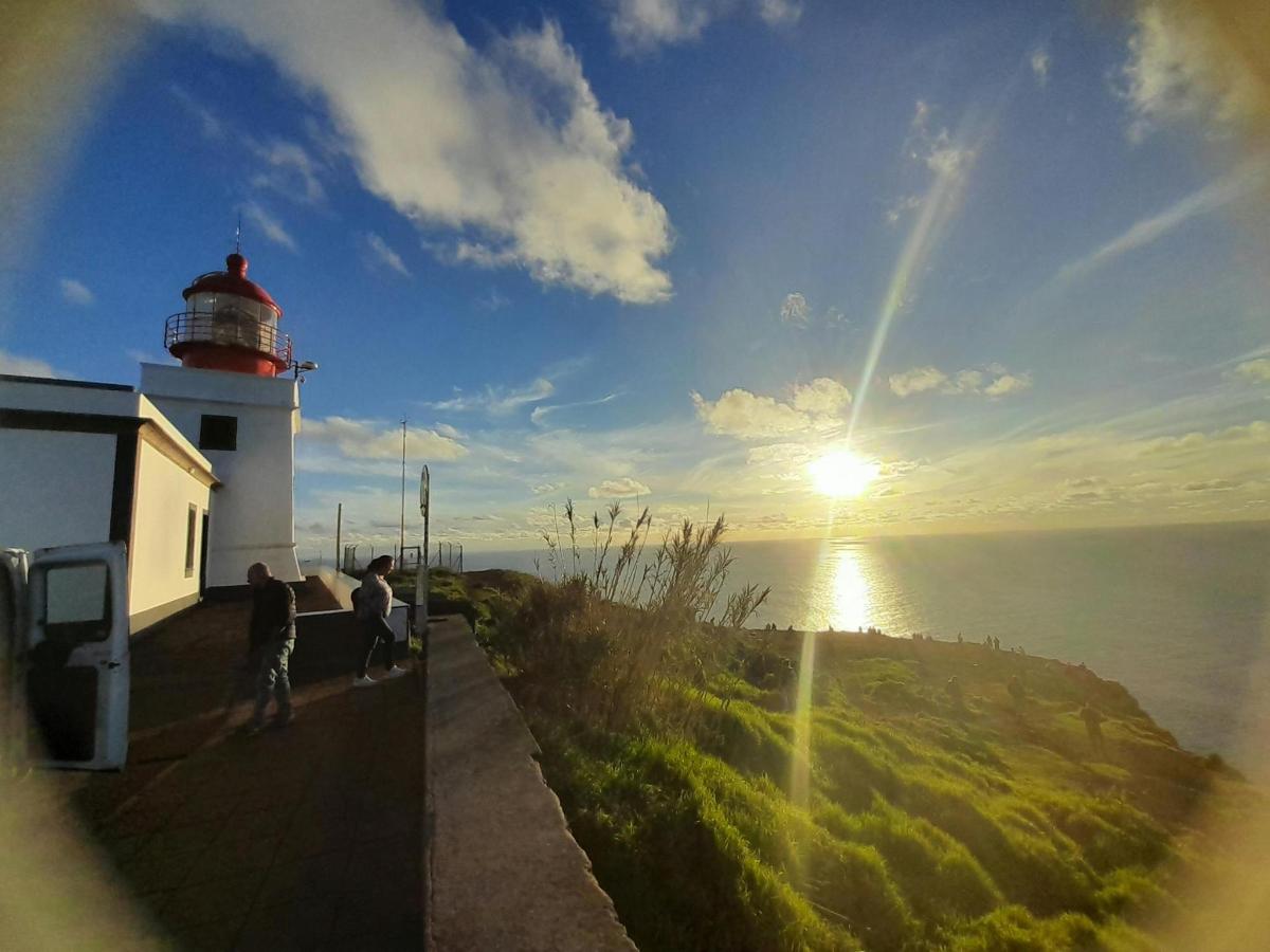ein Leuchtturm auf einem Hügel mit der Sonne am Himmel