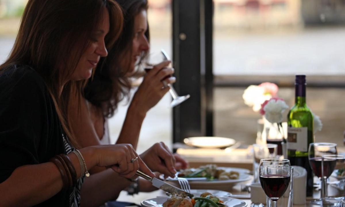 two women sitting at a table eating food