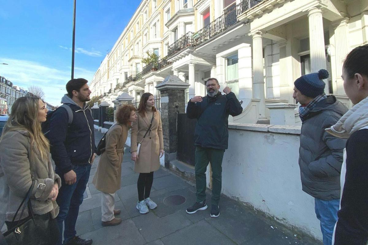 μια ομάδα ανθρώπων που στέκονται σε έναν δρόμο της πόλης