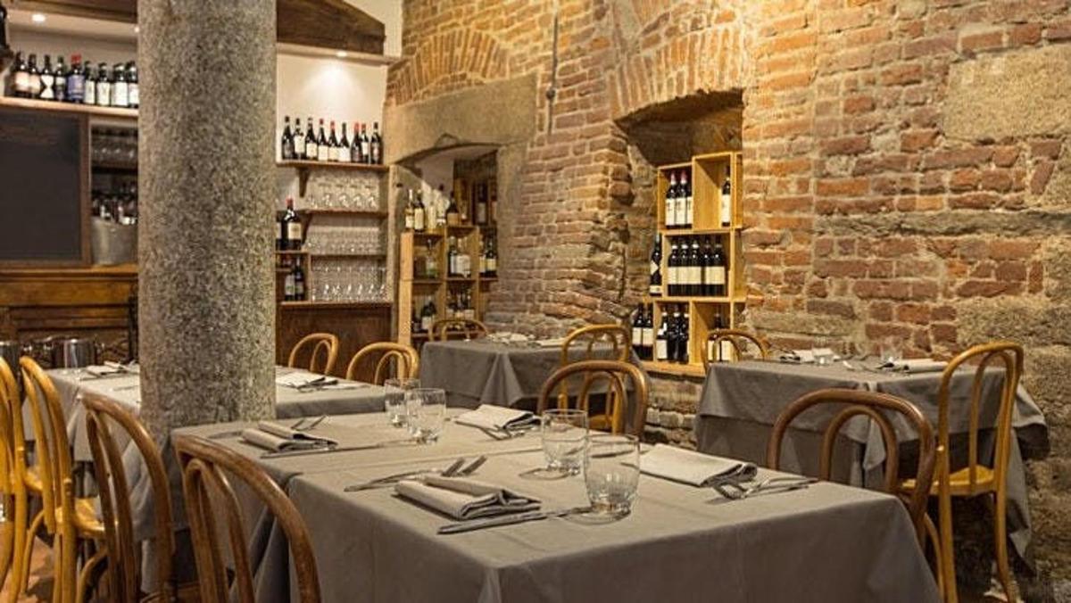 restaurace se stoly a židlemi a cihlovou zdí