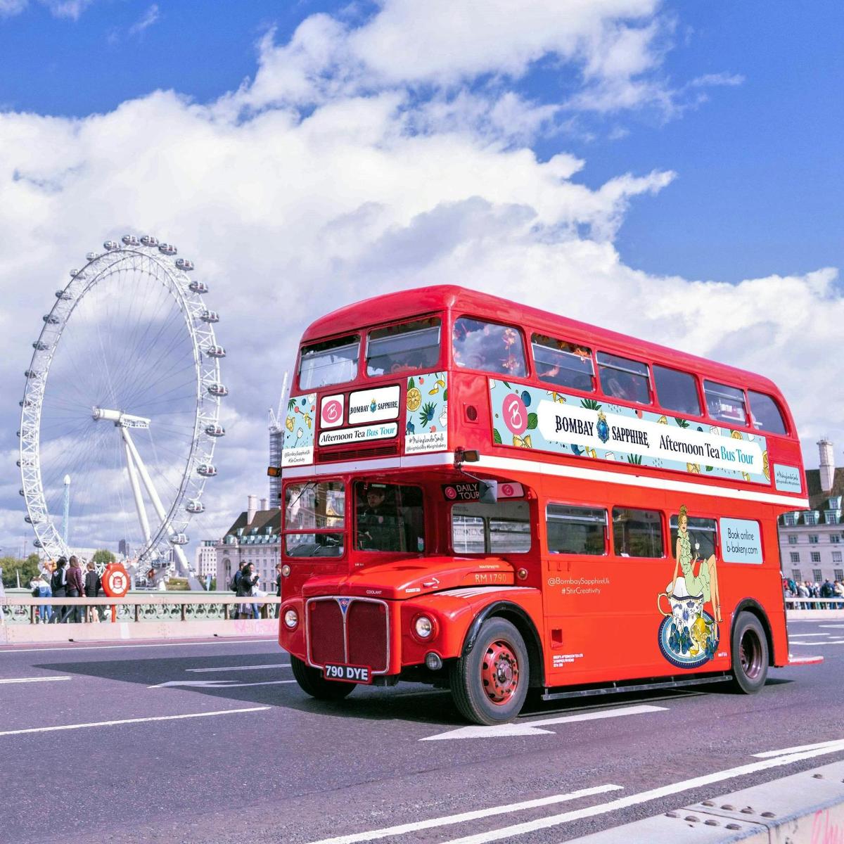 a red double decker bus driving down a street with a wheel