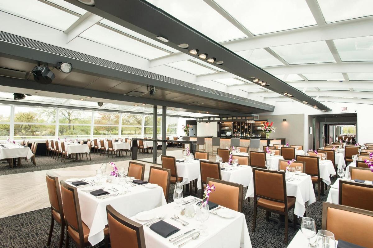 una sala da pranzo con tavoli e sedie bianchi