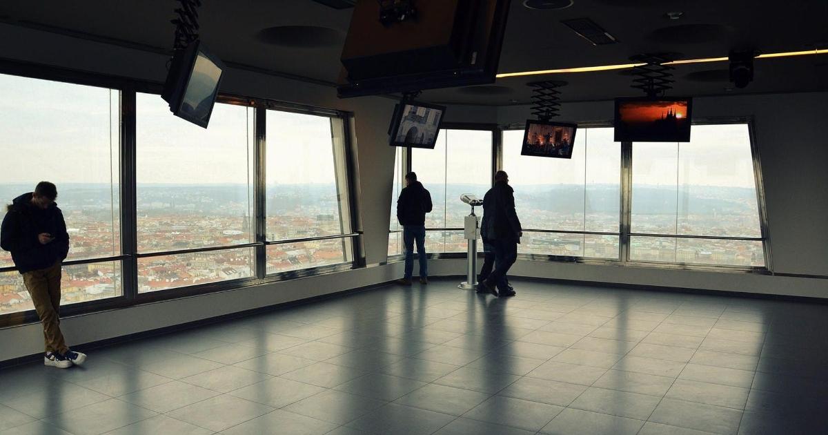 grupp inimesi seisab hoones ja vaatab linna