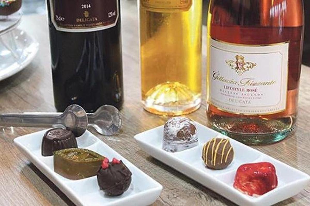 a table with two white plates of desserts and a bottle of wine