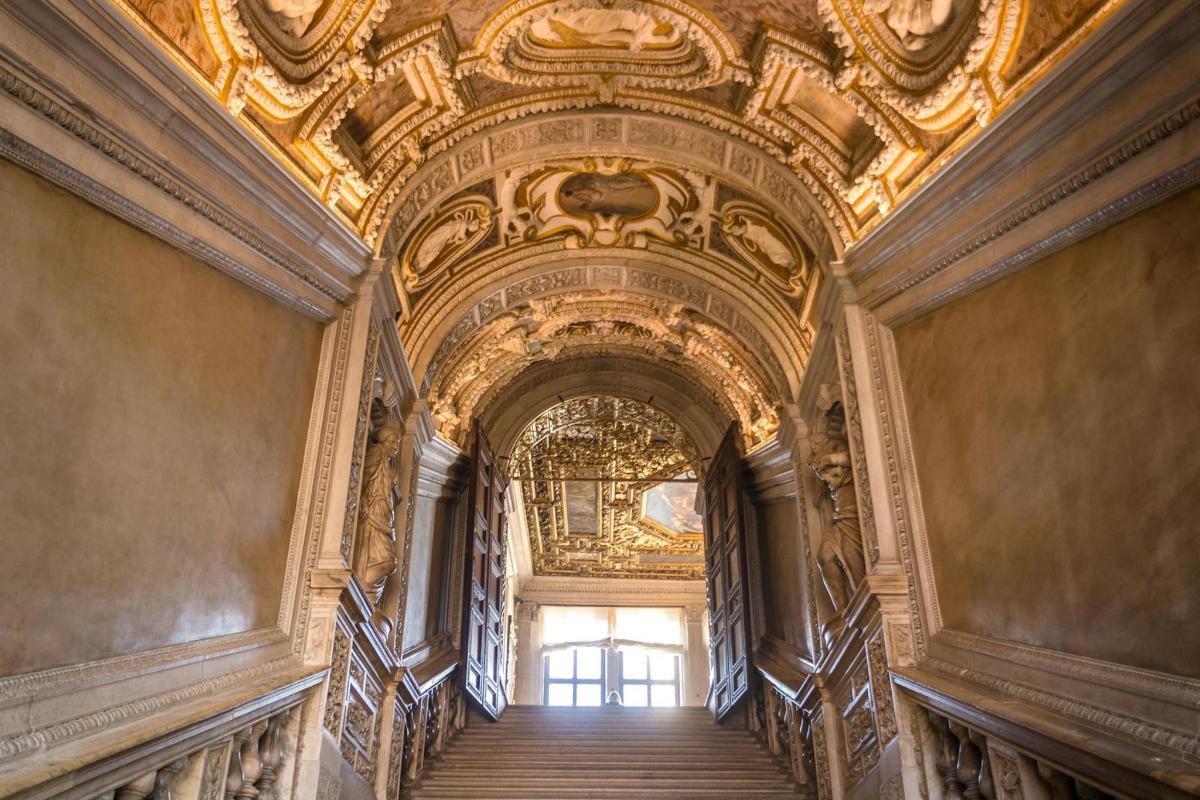 an ornate staircase in a building with a gold ceiling