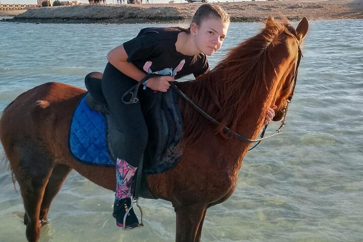 una giovane ragazza a cavallo sulla spiaggia