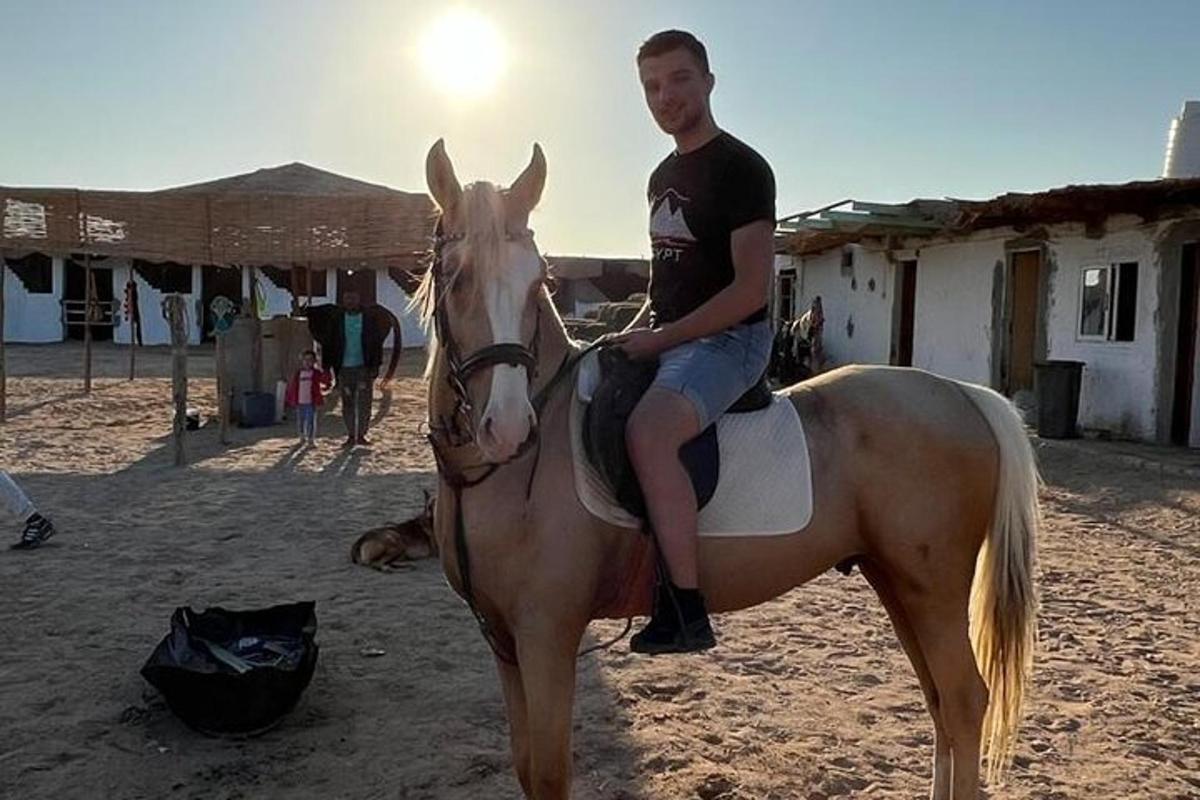 um homem sentado em um cavalo na praia