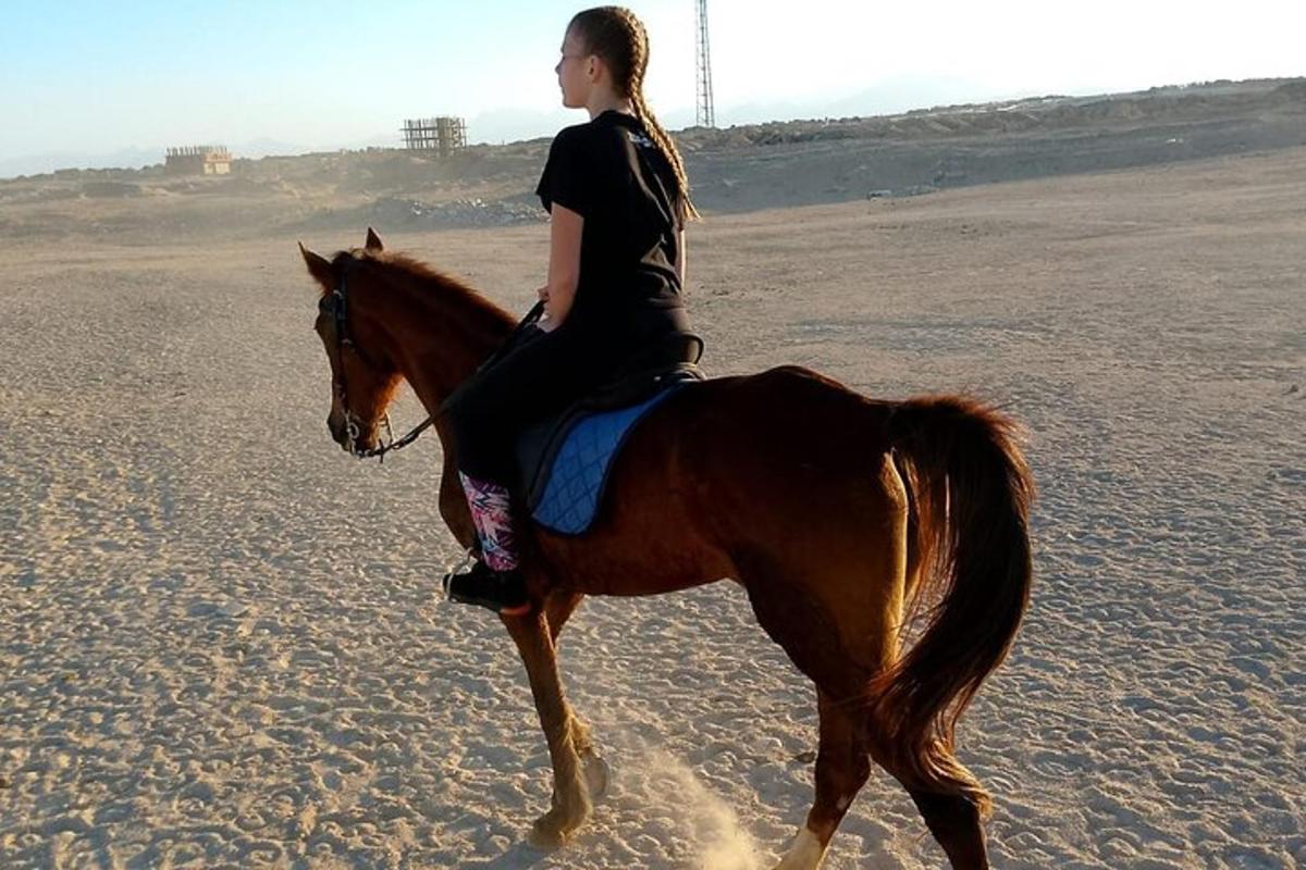 una donna a cavallo sulla spiaggia