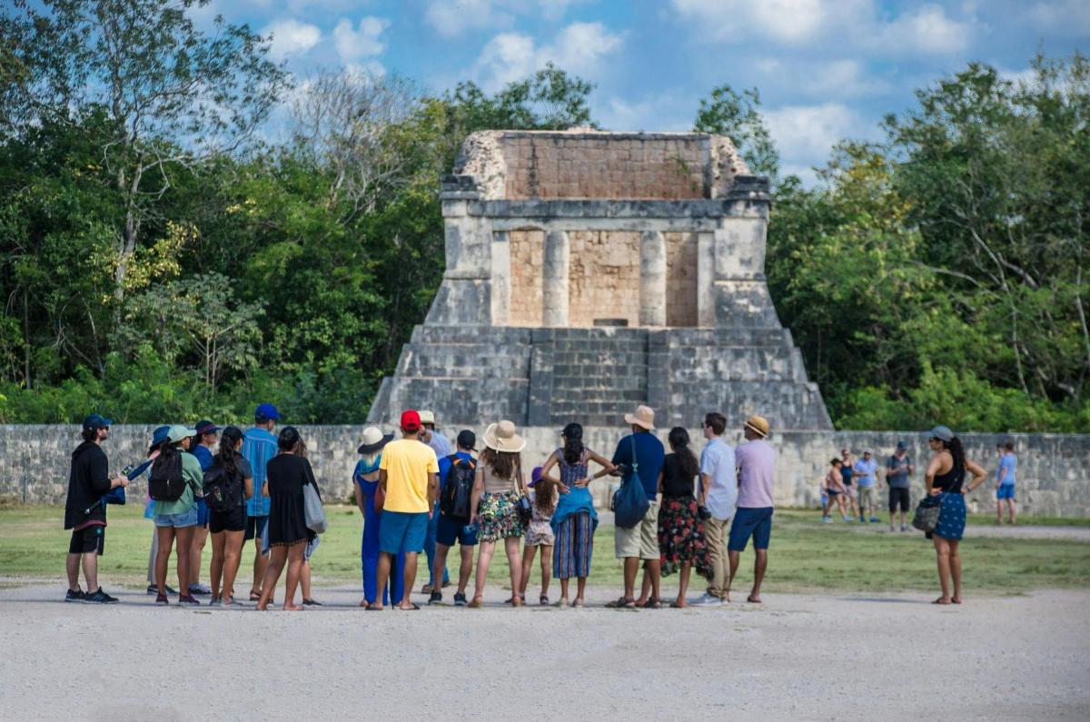 eine Gruppe von Menschen steht vor einer Pyramide