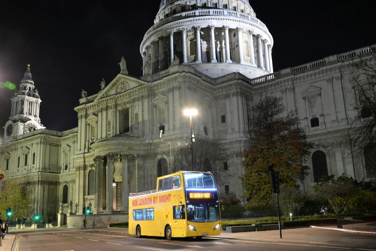 a yellow double decker bus parked in front of a building