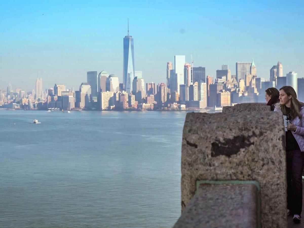 due donne in piedi su un muro con vista sulla città