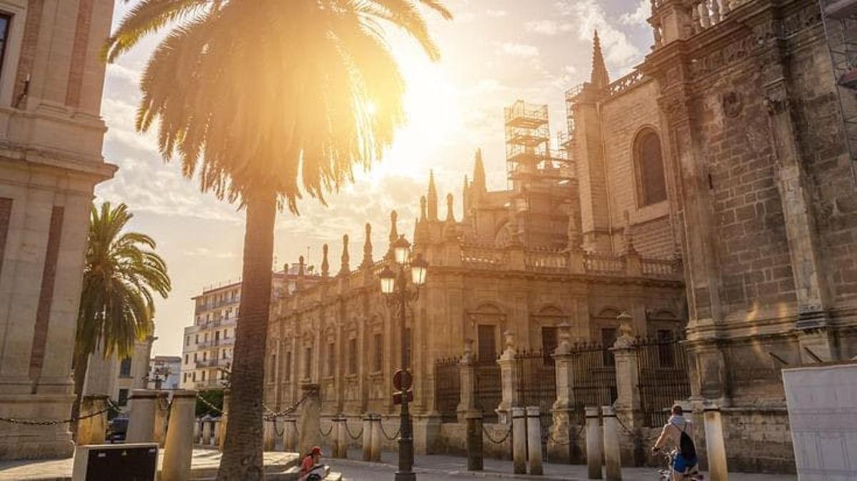 Un edificio antiguo con una palmera delante.