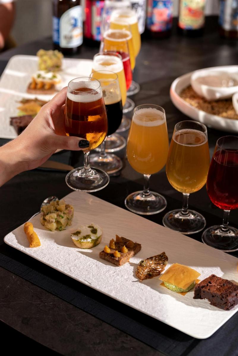 una taula amb un plat de menjar i gots de cervesa