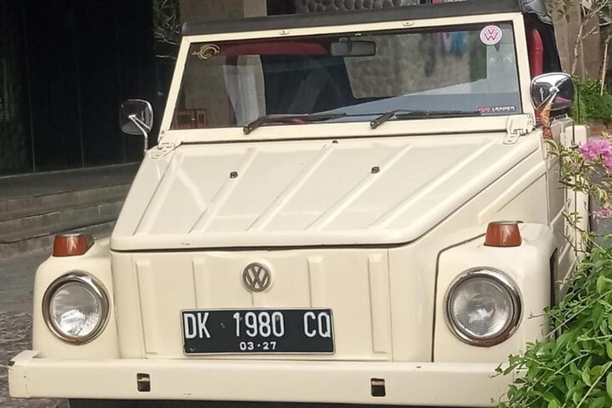 Na ulici stojí staré bílé vozidlo