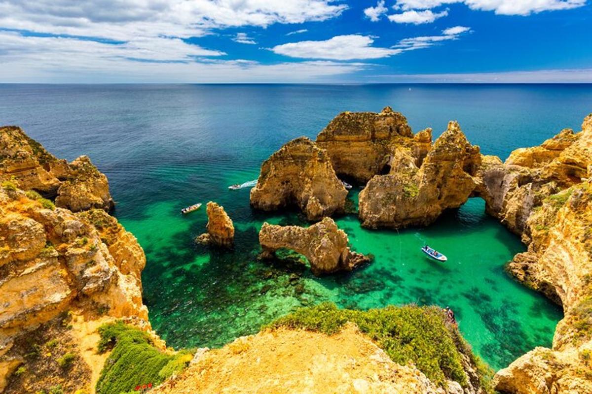 una spiaggia con rocce e barche in acqua