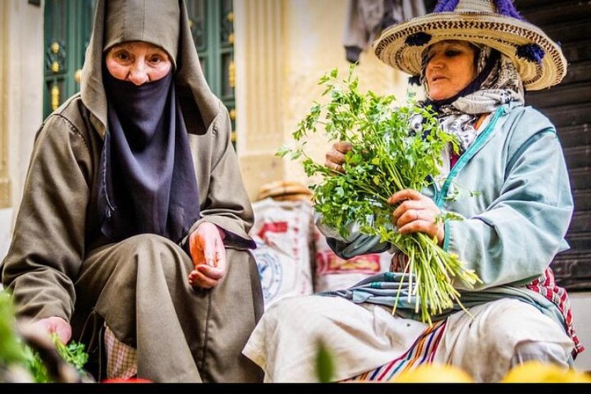 duas pessoas sentadas uma ao lado da outra segurando um monte de verduras