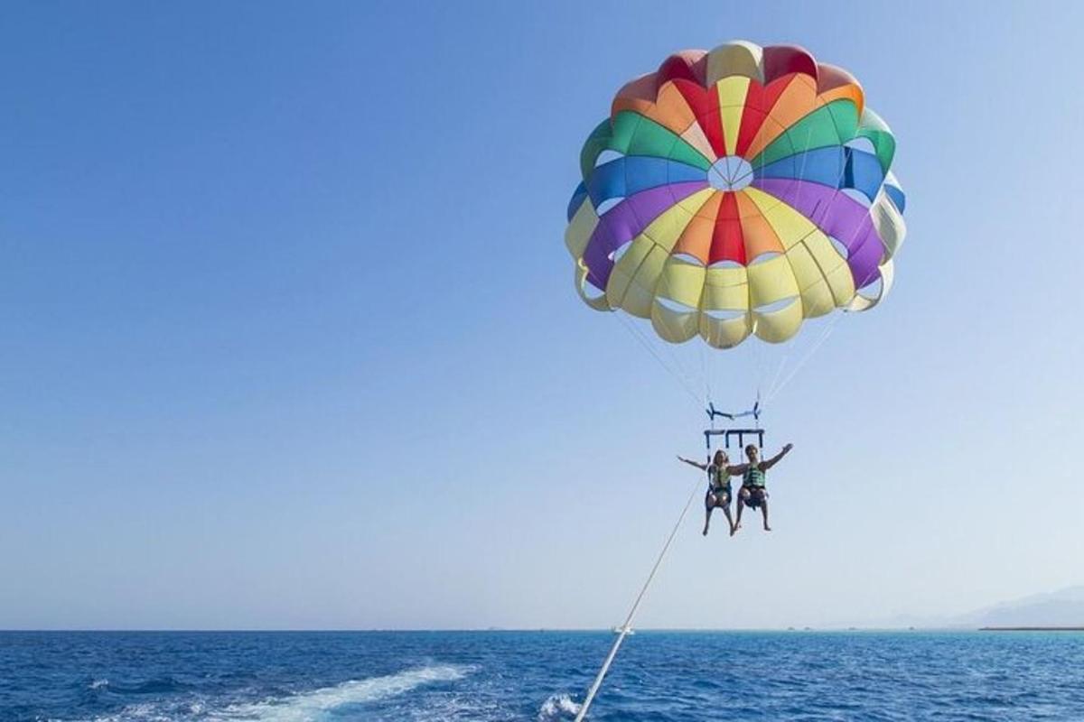 due persone su un paracadute colorato sopra l'oceano