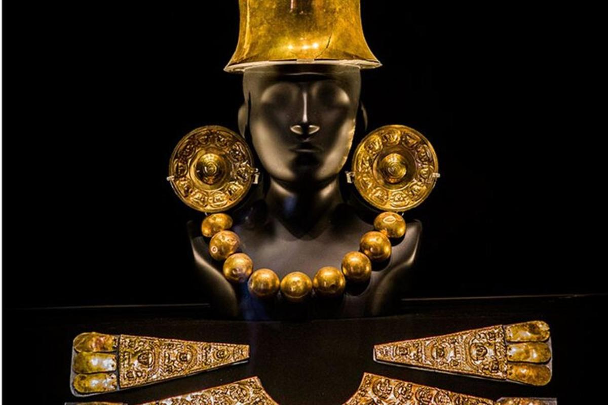 a statue of a god with a bell on its head