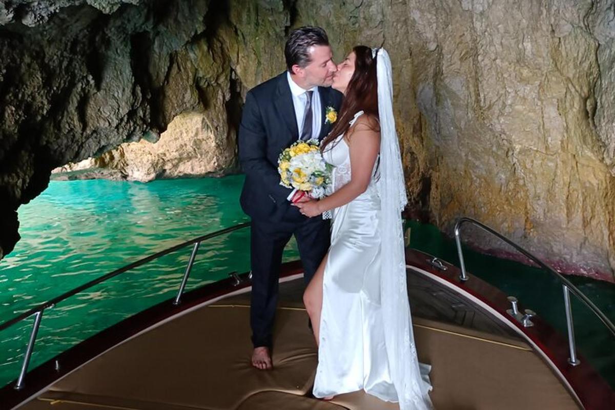 a bride and groom kissing on a boat in a cave