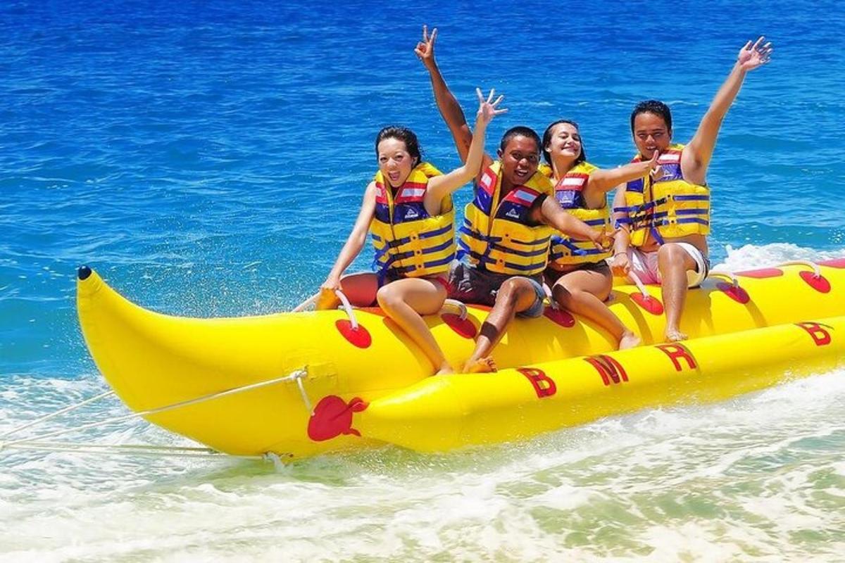 a group of girls riding on a banana boat in the water