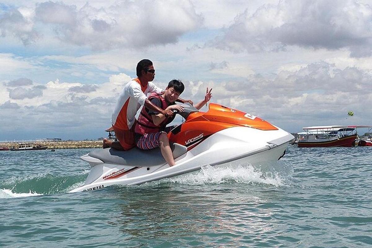 two men riding on a jet ski in the water