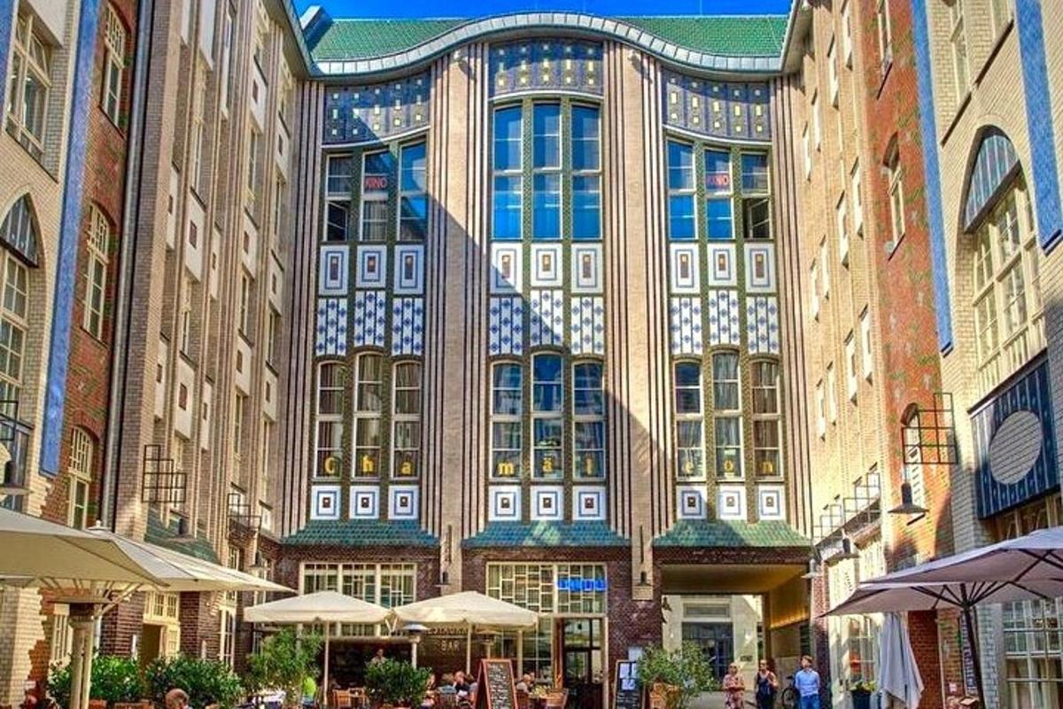 a large building with tables and umbrellas in front of it