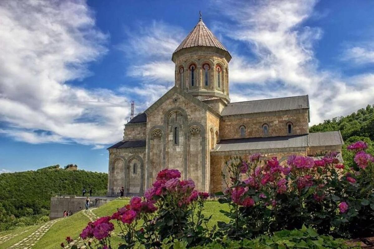uma velha igreja com uma torre em uma colina com flores