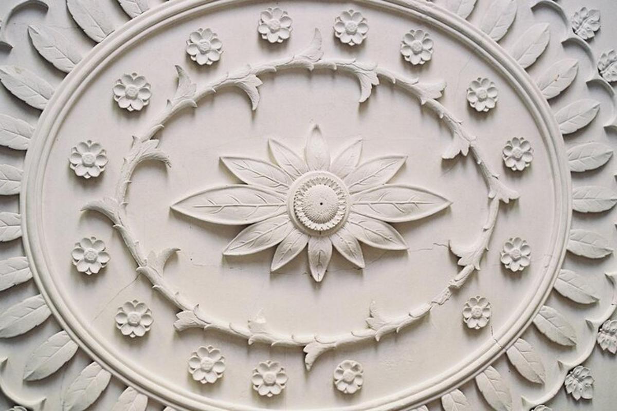 a metal sculpture of a flower on the side of a building