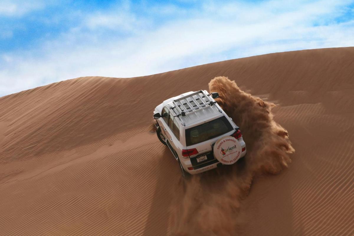 ein Jeep, der durch den Sand in der Wüste fährt