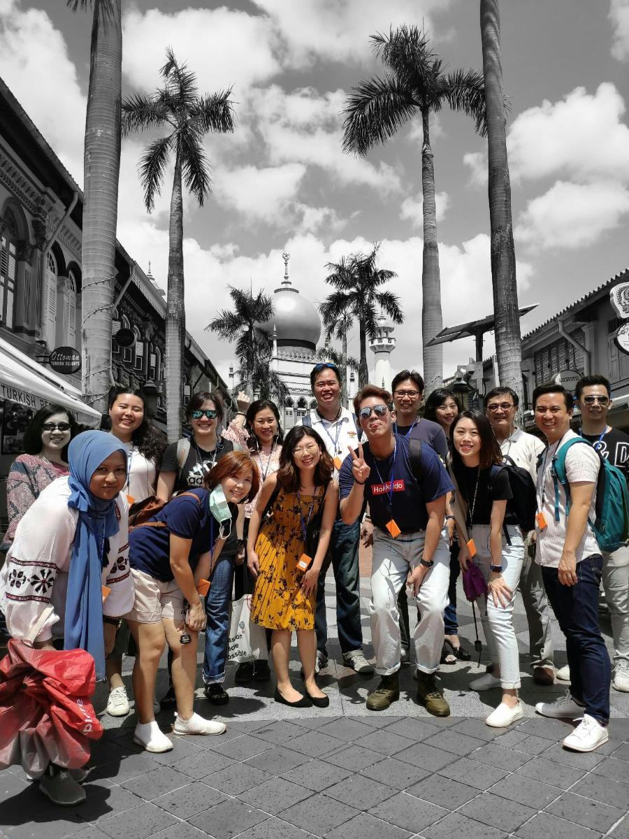 a group of people posing for a picture on a street