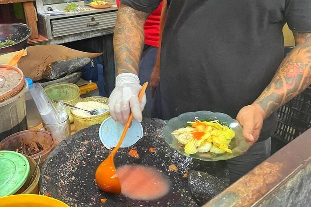 seorang lelaki memasak hidangan di atas panggangan dengan sudu