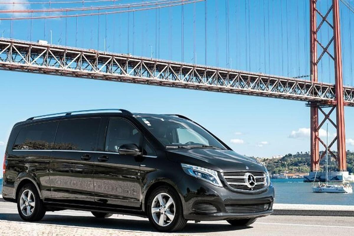 uma van preta estacionada em frente a uma ponte