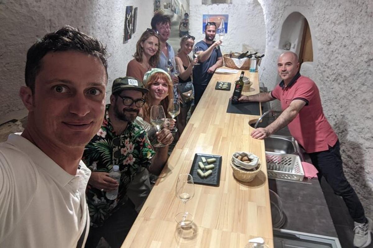 μια ομάδα ανθρώπων που στέκονται γύρω από ένα μπαρ με ποτήρια κρασιού