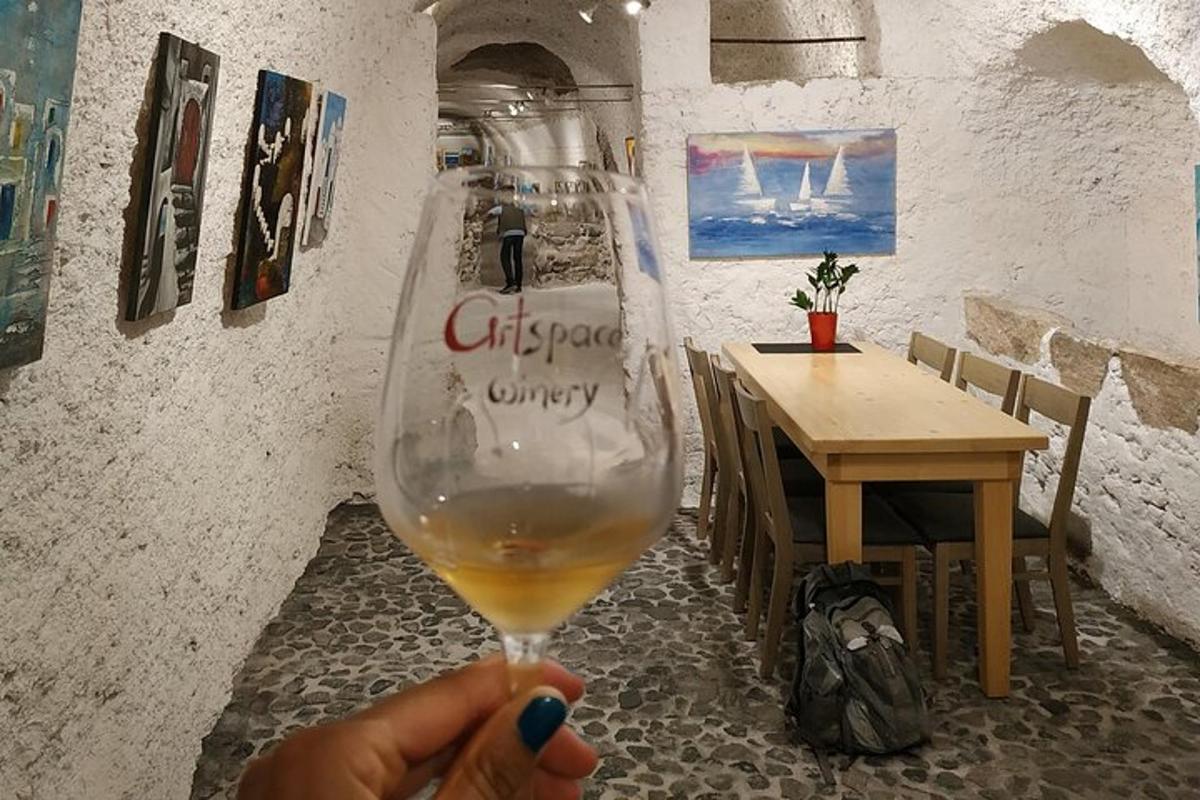 en person, der holder et glas vin på en restaurant