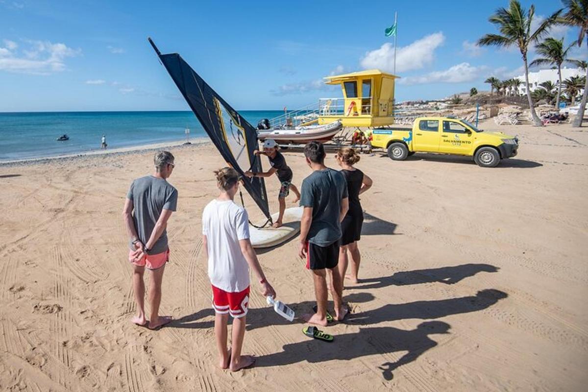 un groupe de personnes debout sur une plage avec une planche de surf