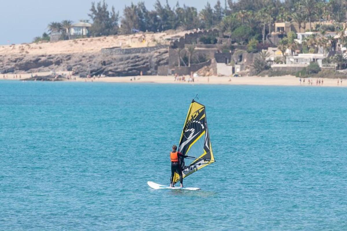 un homme sur une planche de surf avec une voile sur l'océan
