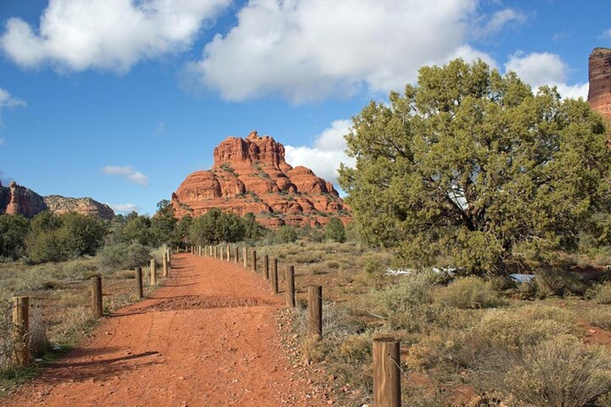Un camino de tierra a través de un desierto con rocas rojas.