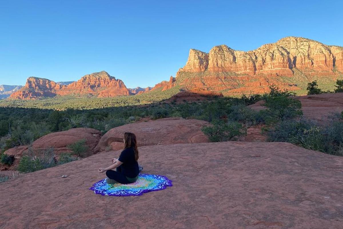 Una mujer sentada en una roca mirando las montañas