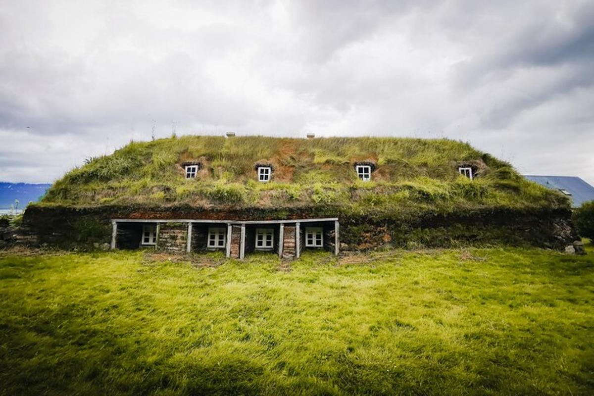 una vecchia casa con l'erba in cima a una collina