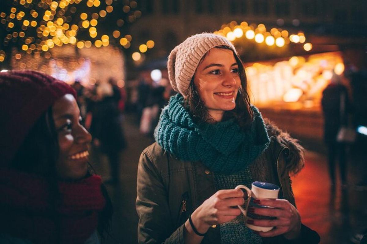 due donne che camminano lungo una strada tenendo in mano una tazza di caffè