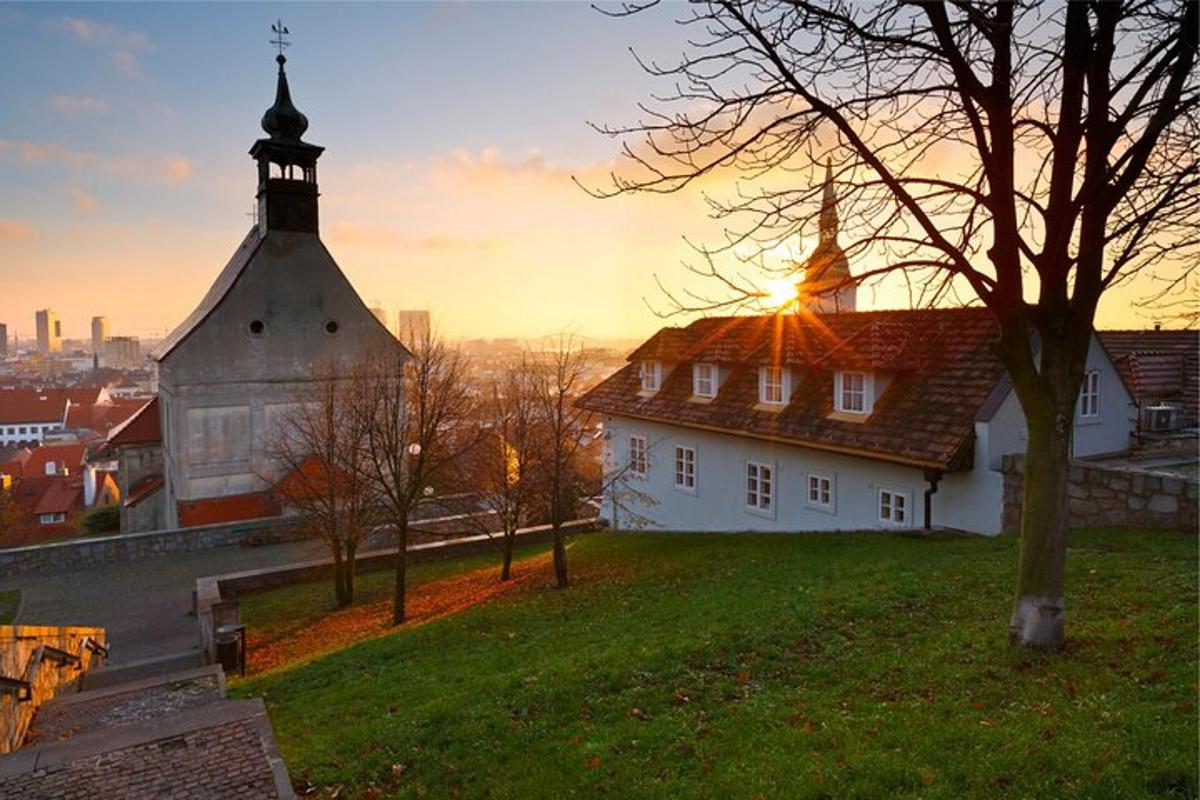 a church on a hill with the sunset in the background