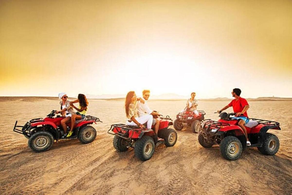 sekumpulan orang menunggang atv di padang pasir