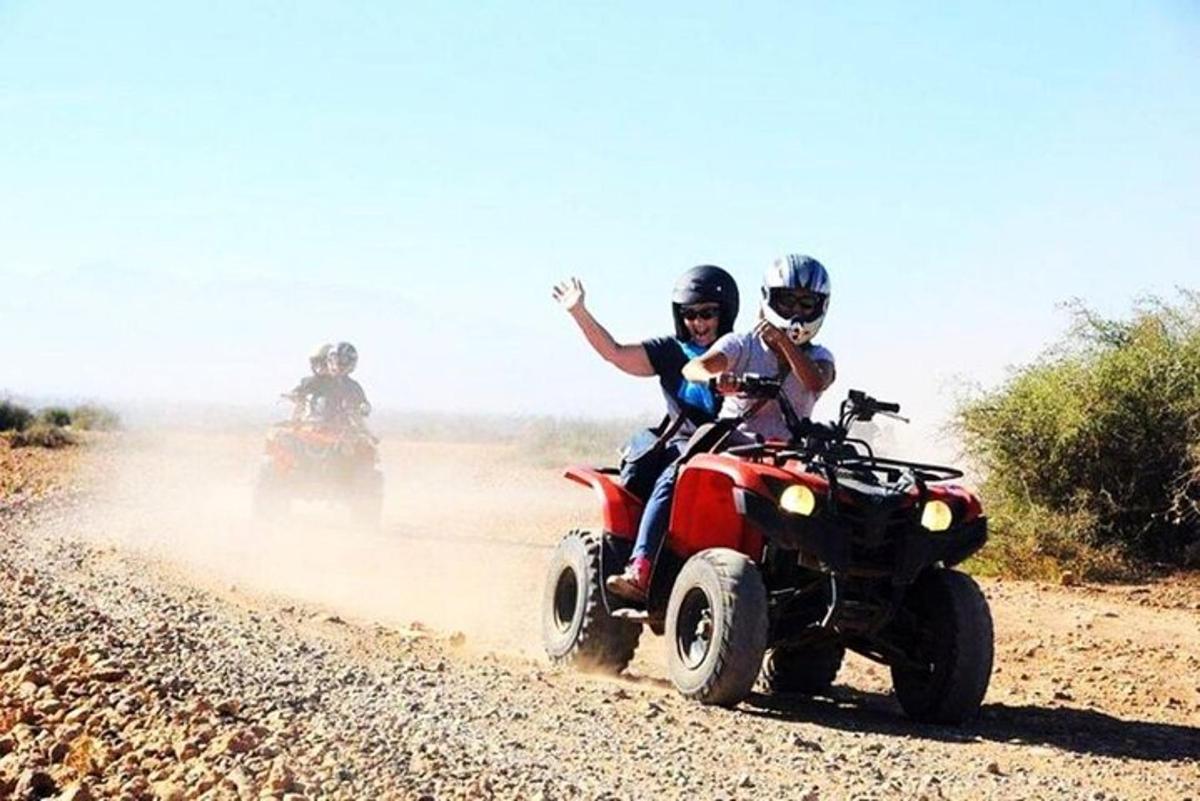 dua orang menaiki atv di jalan tanah