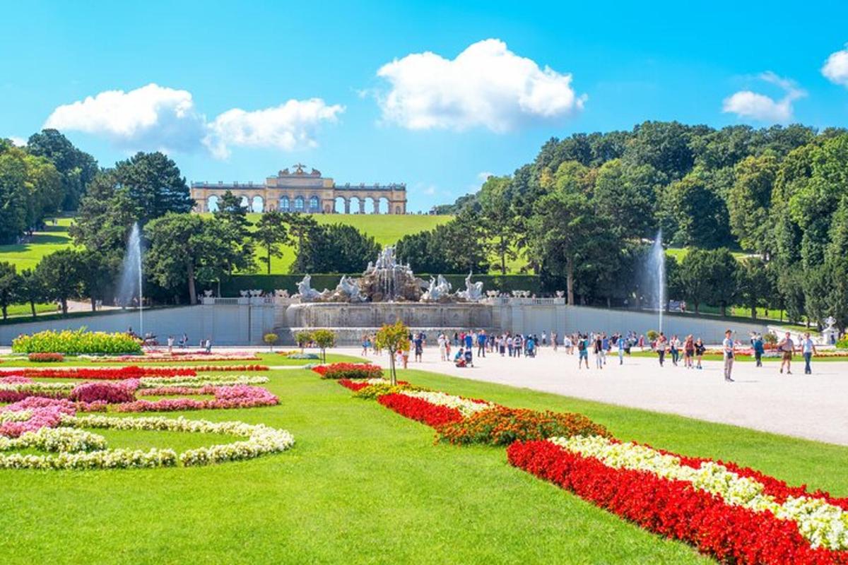egy park szökőkúttal és virágokkal egy épület előtt