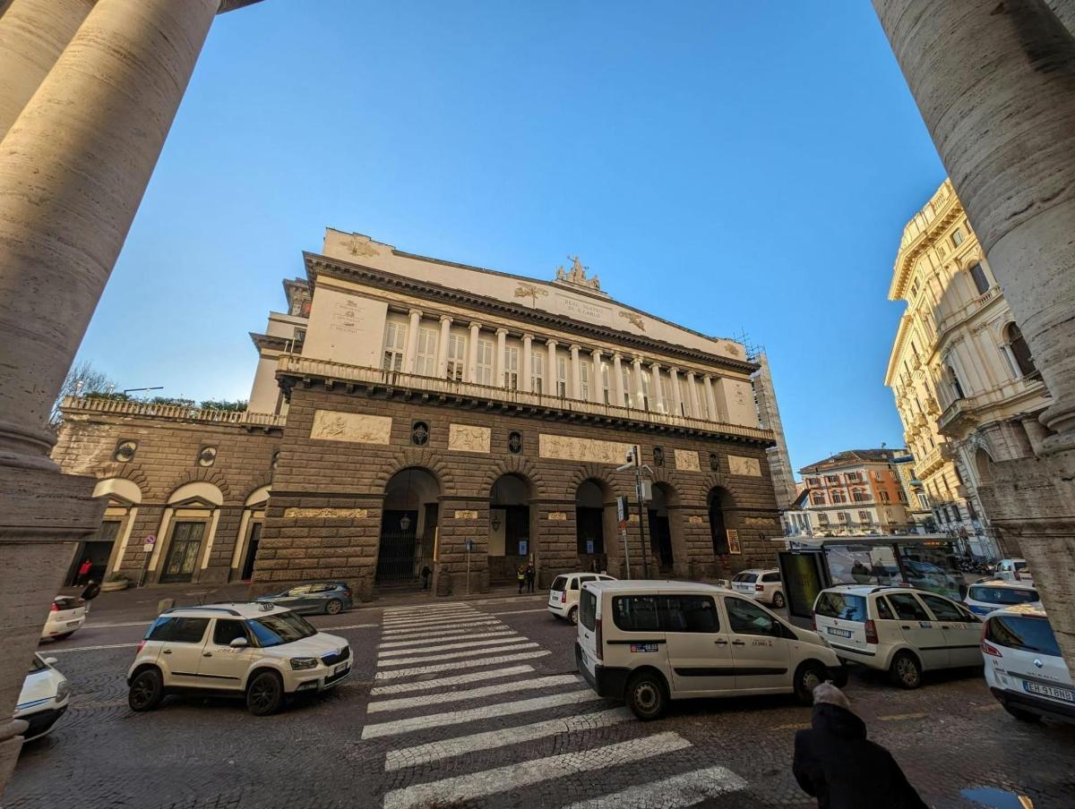 Un edificio antiguo con coches aparcados delante.