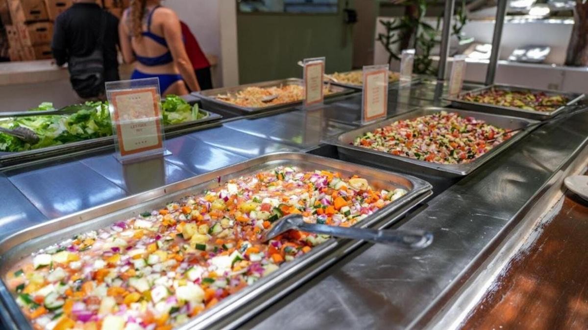 Una línea de buffet con muchos tipos diferentes de comida.