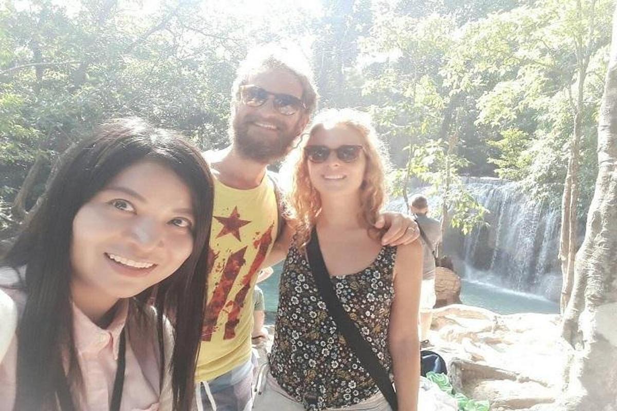 un uomo e due donne in piedi davanti a una cascata