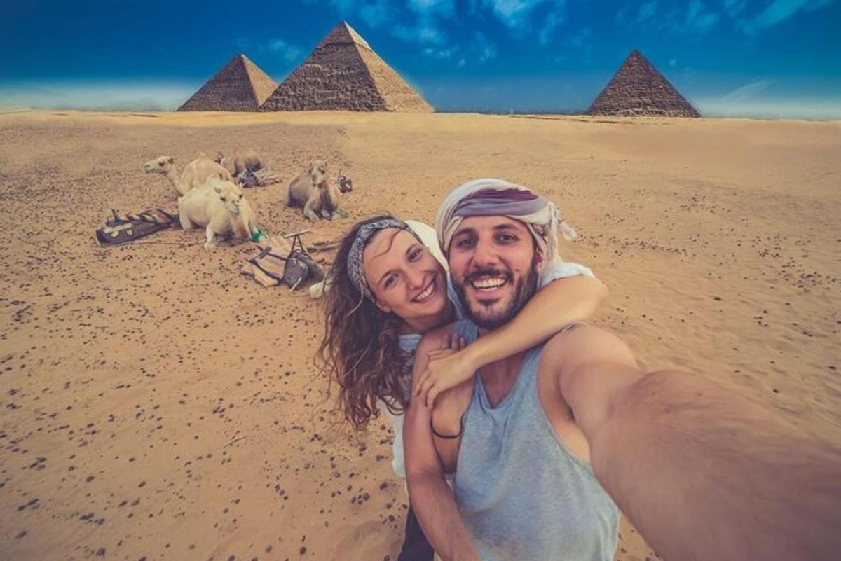 Un hombre y una mujer posando para una foto frente a las pirámides.