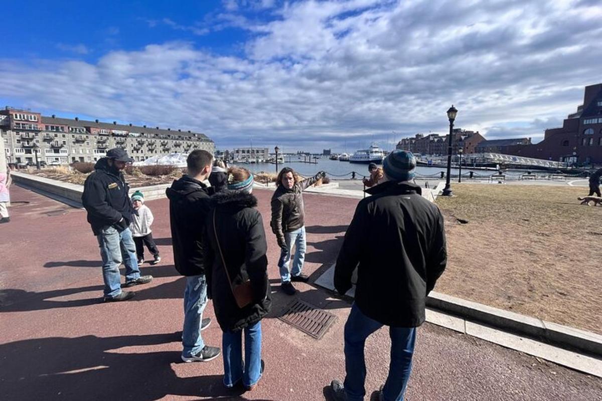 skupina lidí stojících na chodníku u vody